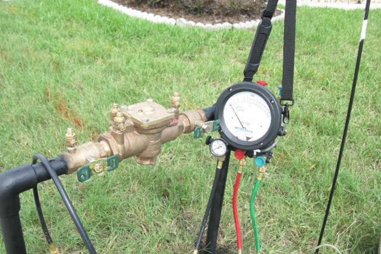 Technician testing a backflow preventer on an irrigation line