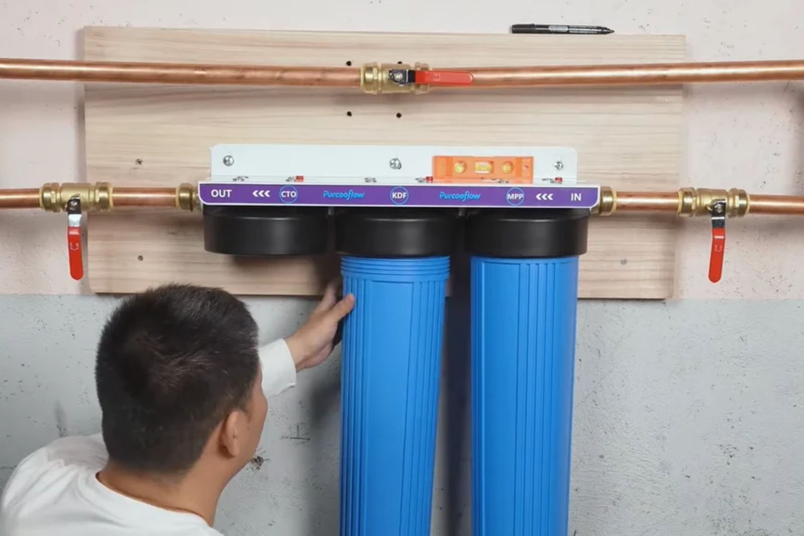 Whole-home water filtration system installed on a wall